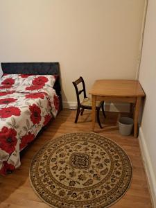 a bedroom with a bed and a table and a rug at London Ilford town house in Ilford +4 photos