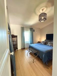 a bedroom with a blue bed and a window at Domaine des Encourdoules in Vallauris