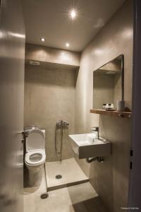 y baño con aseo, lavabo y espejo. en Kochili Apartments, en Néos Pírgos