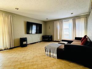 a bedroom with a bed and a flat screen tv at Villa Picasso - 2 Bed Villa in Johannesburg