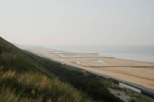 a train traveling down a road next to a beach at Hello Zeeland - Willibrordusplein 28E in Zoutelande
