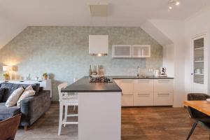 a kitchen and living room with a couch and a table at Hello Zeeland - Willibrordusplein 28E in Zoutelande +22 photos