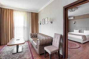 a hotel room with a couch and a bed at Sacvoyage Hotel in Almaty +82 photos