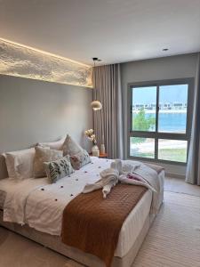 アル・コバールにあるAmwaj Resort For Families Onlyの大きなベッドと大きな窓のある寝室 +122枚の写真