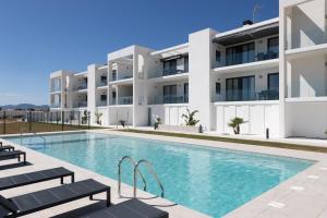 a swimming pool in front of a building at Oliva Suites in Oliva