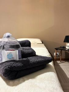 ein Stapel Handtücher auf einem Bett in der Unterkunft COLOR HOUSE- Lecco's Lake in Lecco