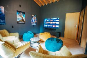 a living room with chairs and a tv and a table at Le Tétras Lyre - 28 pers - Malmedy in Malmedy