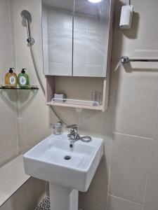 a white bathroom with a sink and a shower at 레토하우스 