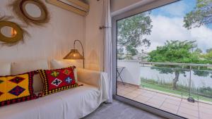 un soggiorno con un divano e una grande finestra di Soltroia Duplex, Lake & Beach by LovelyStay a Tróia