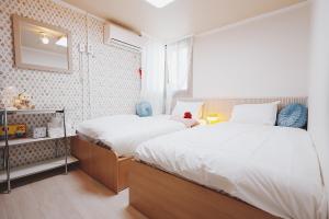 a bedroom with two beds and a window at 레토하우스 