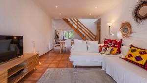 un soggiorno con divani bianchi e TV a schermo piatto di Soltroia Duplex, Lake & Beach by LovelyStay a Tróia Altre 28 foto