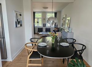ein Esszimmer mit einem schwarzen Tisch und Stühlen in der Unterkunft City Center Apartment with Balcony, Garden & Free Parking in Odense