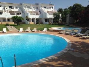 a swimming pool in front of a building at Vilamar in Luz