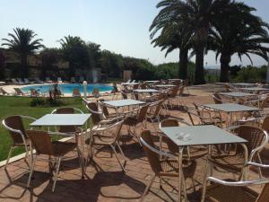 a row of tables and chairs next to a pool at Vilamar in Luz