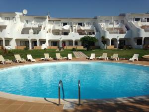 a swimming pool in front of a large building at Vilamar in Luz