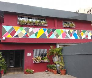 a red building with a colorful mural on it at The Cate House in Lagos
