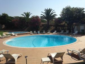 a large swimming pool with chairs and chairs in a resort at Vilamar in Luz +37 photos