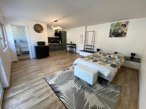 a bedroom with a bed and a living room at Studio climatisé 30 m2 à 2 min de Colmar in Horbourg
