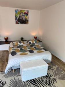 a bedroom with a bed and a painting on the wall at Studio climatisé 30 m2 à 2 min de Colmar in Horbourg