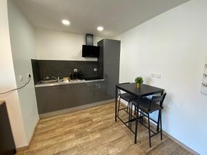 a kitchen with a black table and a sink at Studio climatisé 30 m2 à 2 min de Colmar in Horbourg +3 photos
