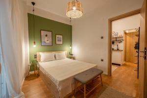 a bedroom with a bed and a green wall at The Uppertown Nest - By Urban Minds in Thessaloniki +23 photos