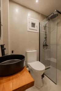 a bathroom with a black bath tub next to a toilet at The Uppertown Nest - By Urban Minds in Thessaloniki
