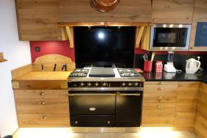 a kitchen with a stove and a microwave at Chalet Le Petit Suisse in Thollon