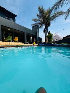 a large blue swimming pool in front of a building at Villa Picasso - 3 Bed Villa in Johannesburg