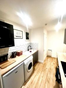 a kitchen with a washer and dryer in it at Large one bedroom beach apartment in Bel Royal +13 photos