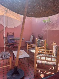 une pièce avec des chaises et une table avec un parasol dans l'établissement Riad Anisse, à Marrakech