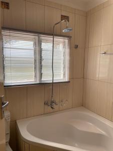 ヌドラにあるHillview Homes Apartmentのバスタブと窓のあるバスルーム +20枚の写真