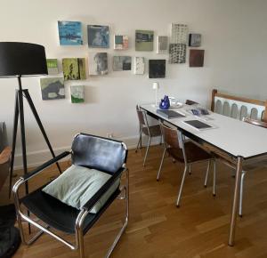 a room with a desk with chairs and a table with a lamp at artroom in Bern