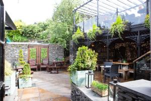 an outdoor patio with tables and chairs and plants at The Albert in Bowness-on-Windermere