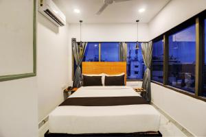 a bedroom with a bed and a large window at Super Townhouse Rcc Hotel Banjara Hills in Hyderabad