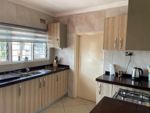 a kitchen with wooden cabinets and a sink at Hillview Homes Apartment in Ndola