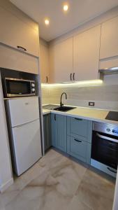 a kitchen with a white refrigerator and a sink at New! Sea View Apartment with Aircon in Center of Las Americas in Playa de las Americas
