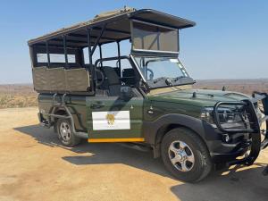 a green military vehicle parked in the desert at Monoshez Bush Camp in Nsikazi