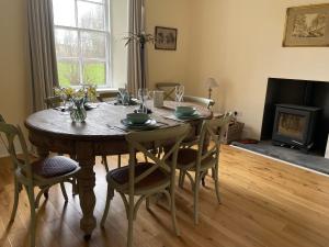 a dining room with a table with chairs and a fireplace at Oldwood. Fyvie. in Turriff