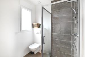 a bathroom with a toilet and a glass shower at Bienvenue - 500 m de la plage in Courseulles-sur-Mer +12 photos