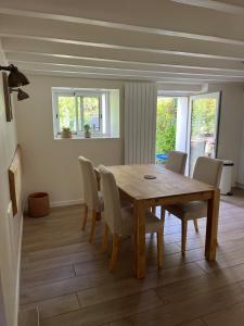 een eetkamer met een houten tafel en stoelen bij La Maison Rose in Saint-Armel +8 foto's