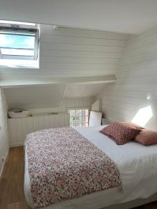 een slaapkamer met een bed en een raam bij La Maison Rose in Saint-Armel