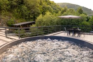 einen Whirlpool auf einer Terrasse mit einem Tisch und Stühlen in der Unterkunft Pensiunea El Sol 