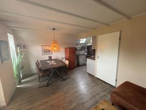 a living room with a table and a kitchen at Haus Reiher am Lauwersmeere176 in Anjum +36 photos