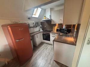 a small kitchen with a refrigerator and a sink at Haus Reiher am Lauwersmeere176 in Anjum