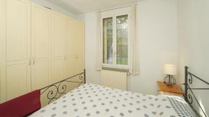 una camera da letto bianca con un letto e una finestra di Garda Prestige Retreat a Moniga