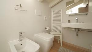 un bagno bianco con un water e un lavandino di Garda Prestige Retreat a Moniga Altre 29 foto