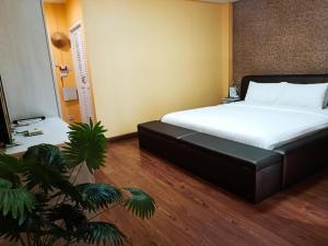 a bedroom with a bed and a plant in it at ๋Jongluxpakdee โรงแรมจงรักษ์พักดี in Uttaradit