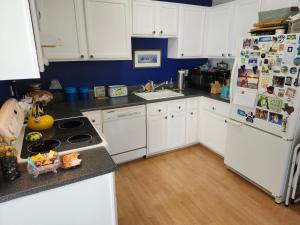 a kitchen with white cabinets and a white refrigerator at Centrally located; Walk anywhere! in San Francisco