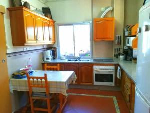 a kitchen with wooden cabinets and a table and a sink at Spacious Villa in Guillena with Garden and Private Pool in Guillena +56 photos