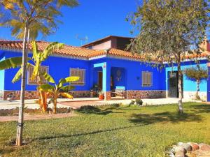 a blue house with trees in front of it at Spacious Villa in Guillena with Garden and Private Pool in Guillena